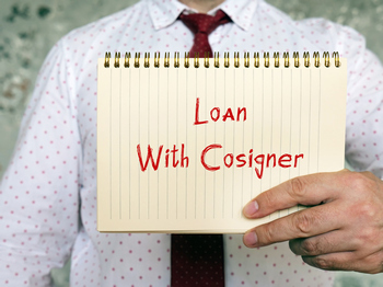 Man holding a sign that says "Loan with cosigner"